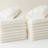Two stacks of CloudCloth 100% Organic Cotton Facial Cleansing Cloths. Off white, with woven loop tag showing. Face Cloths perfect for gentle removal of makeup and skincare products like cleansers. Made in Britain. 